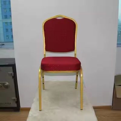 Elegantes sillas de banquete de hotel con cojín de tela roja apilables de metal dorado para fiestas y bodas